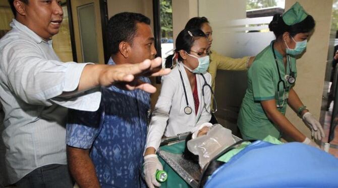 Eine Verletzte wird nach der Bruchlandung eines Flugzeugs vor Bali versorgt. Foto: Made Nagi