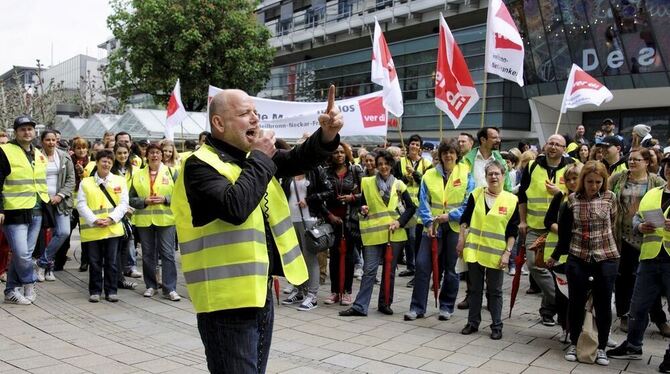 Der Stuttgarter Verdi-Geschäftsführer Cuno Hägele (vorn) spricht zu Mitarbeitern des Einzelhandels während eines Warnstreiks in