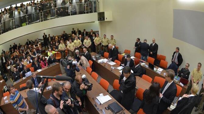 Die Angeklagte Beate Zschäpe (Gruppe rechts unten in der Mitte) steht im Gerichtssaal in München neben ihren Anwälten. Foto: