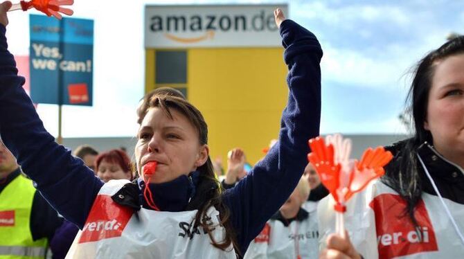 Beschäftigte des Internet-Versandhändlers Amazon streiken vor dem Werkstor in Leipzig. Foto: Hendrik Schmidt/Archiv