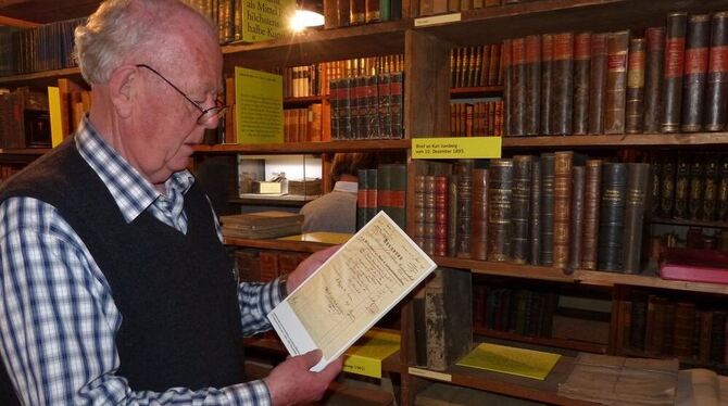 Rolf Hagenlocher studiert eine vom Lehrling Hermann Hesse ausgestellte Rechnung für eine Lieferung an die höhere Mädchenschule T