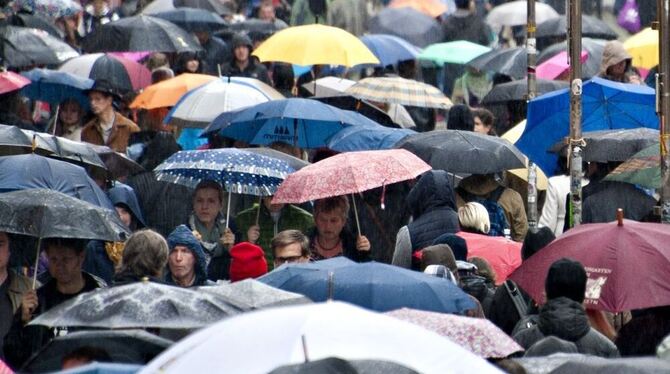 Passanten mit Regenschirmen gehen in Stuttgart über die Königstraße. Foto: dpa