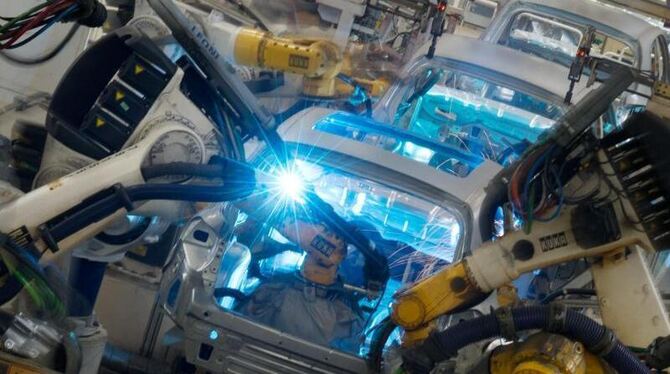Roboter schweißen im VW-Werk in Wolfsburg die Karosserien vom Tiguan Modell. Foto: Jochen Lübke