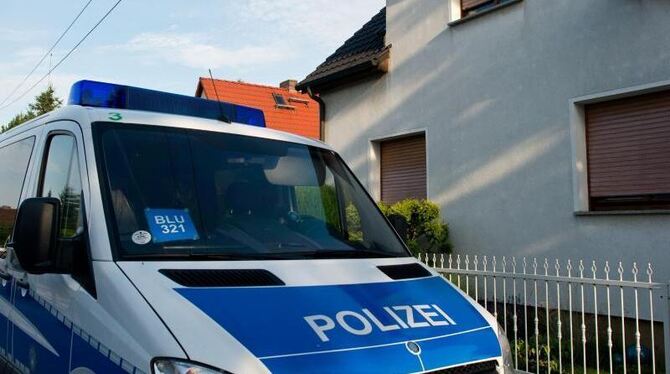 Einsatzbereit: ein Polizeiwagen vor dem Haus eines Verdächtigen. Foto: Patrick Pleul