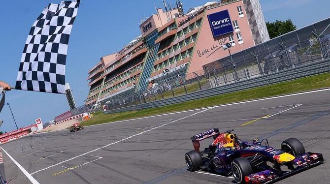 Sebastian Vettel überquert mit seinem Red Bull die Ziellinie als Erster. Foto: David Ebener
