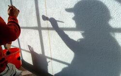 Der Schatten eines Malers zeichnet sich auf einer Hauswand ab. Foto: Patrick Pleul