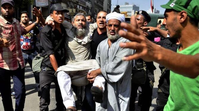 Kairo: Ein Mursi-Anhänger wird von Sicherheitskräften getragen. Foto: Mostafa Darwisch