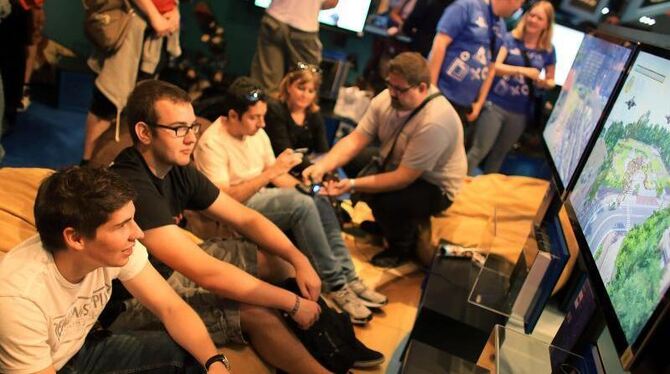 Computerspieler probieren auf der Gamescom in Köln am Stand von Sony die neue PlayStation 4 aus. Foto: Oliver Berg