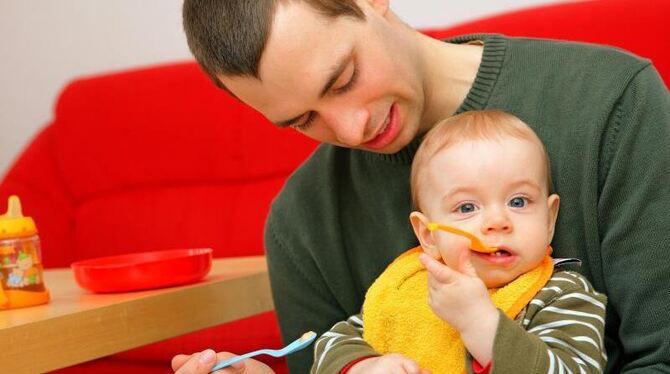 Ein junger Vater füttert seinen Sohn: Mehr als jeder vierte Vater eines neugeborenen Kindes geht inzwischen in Elternzeit. Fo