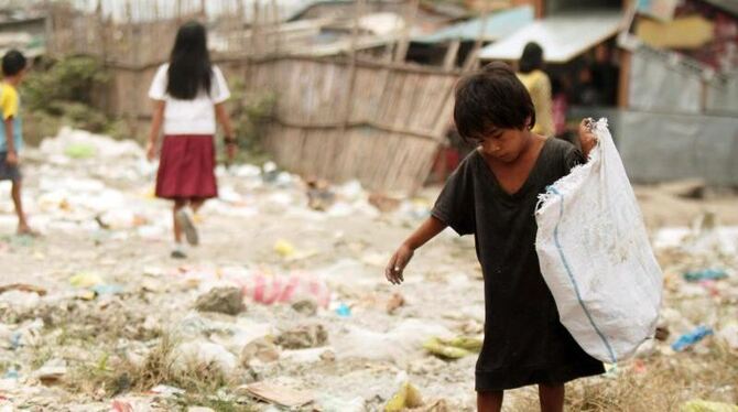 Ein philippinischer Junge sammelt Müll: Millionen Kinder auf der Welt gehen nicht zur Schule. Stattdessen müssen sie den ganz