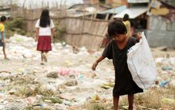 Ein philippinischer Junge sammelt Müll: Millionen Kinder auf der Welt gehen nicht zur Schule. Stattdessen müssen sie den ganz
