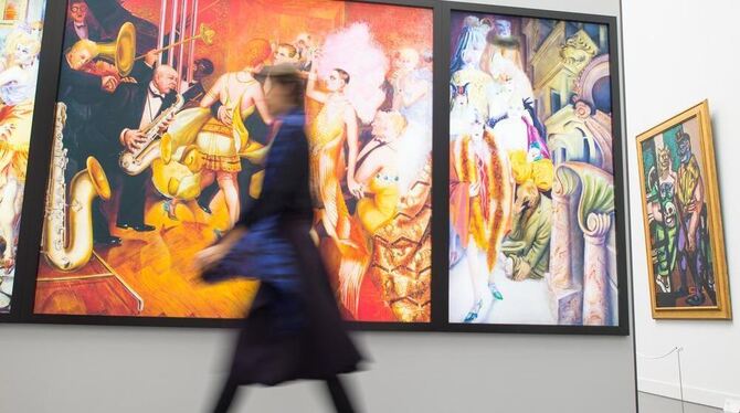 Eine Frau geht in Mannheim in der Kunsthalle in der Ausstellung »Dix/Beckmann: Mythos Welt« an der Reproduktion eines Werkes des