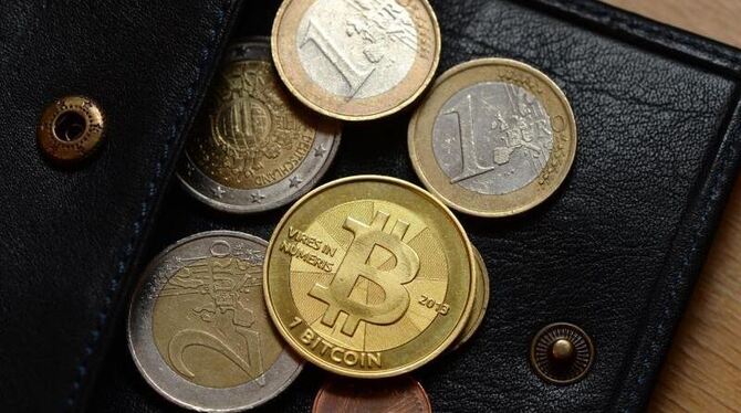 Eine Bitcoin-Münze liegt zwischen Euro-Münzen in Berlin im Betahaus auf der Bitcoin Exchange Berlin, einer monatlich stattfin