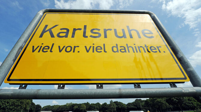 An der Karlsruher Südtangente steht ein überdimensionales Ortsschild, auf dem der Karlsruher Werbeslogan "Karlsruhe viel vor. vi