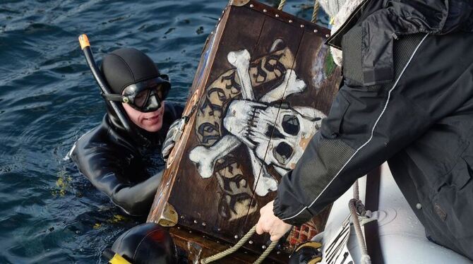 Die Taucher Thorsten Werner (links) und Donia Amer hieven vor Überlingen beim traditionellen Dreikönigstauchen eine hölzerne Sch
