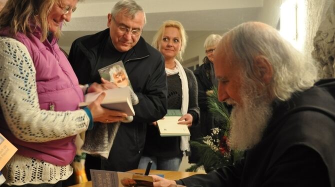 Der Andrang war groß: Nach seinem Vortrag musste Pater Anselm Grün in Eningen viele Bücher signieren.  FOTO: SEITZ
