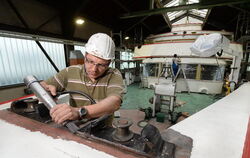 Der Maler Simon Mangold entfernt in der Werft der Bodenseeschiffsbetriebe in Friedrichshafen den Lack am Passagierschiff "Konsta