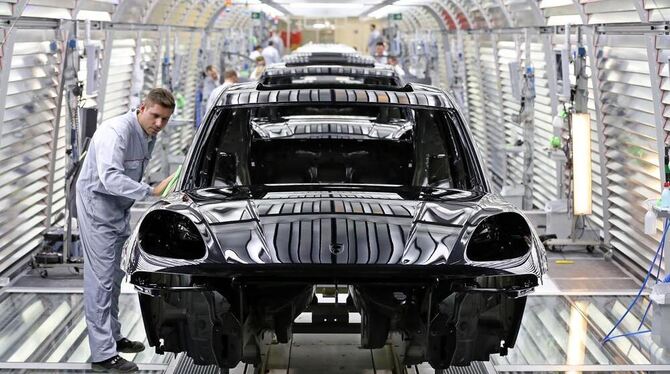 Ein Porsche-Mitarbeiter prüft die Lackierung eines neuen Porsche Macan im Porsche-Werk in Leipzig.