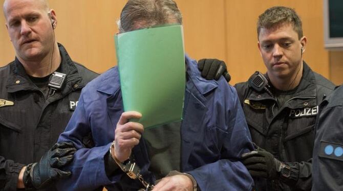 Einer der beiden Angeklagten wird in Handfesseln von Polizisten in den Verhandlungssaal des Landgerichts Augsburg geführt. Fo