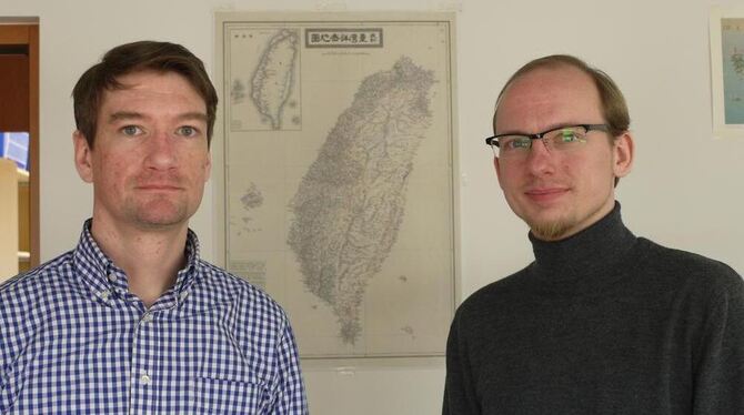Stefan Braig, geschäftsführender Direktor am ERCCT(links), und André Beckershoff, Doktorand, vor einer Karte von Taiwan. FOTO: G