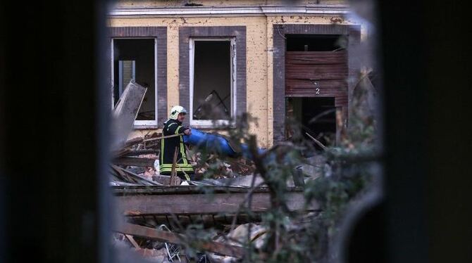 Ein Feuerwehrmann arbeitet in Itzehoe an der Unfallstelle des explodierten Mehrfamilienhauses. Foto: Axel Heimken