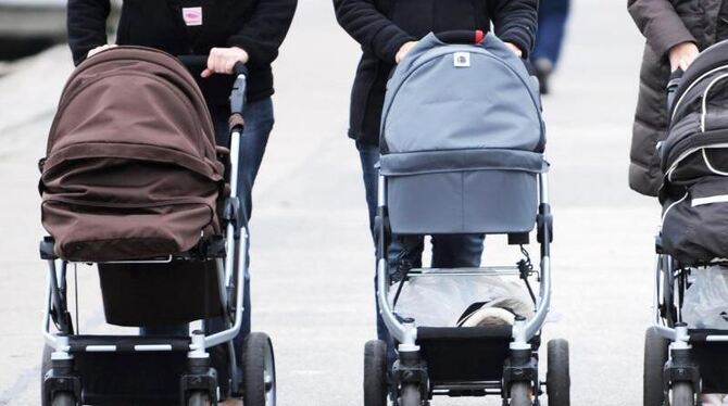 Frauen schieben ihre Kinderwagen über eine Promenade. Foto: Marcus Brandt/Symbolbild