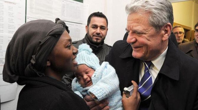 Bundespräsident Gauck beim Besuch eines Übergangswohnheimes für Asylbewerber. Foto: Bernd Settnik/Archiv