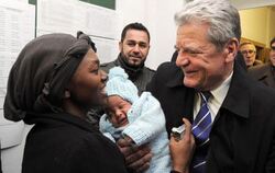 Bundespräsident Gauck beim Besuch eines Übergangswohnheimes für Asylbewerber. Foto: Bernd Settnik/Archiv