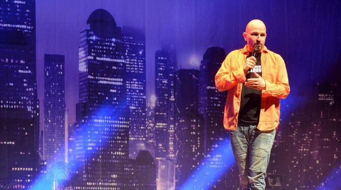 Dominik Kuhn alias Dodokay in der Porsche-Arena vor der Kulisse der großen Welt, die bei ihm schwäbisch ist. FOTO: NIETHAMMER