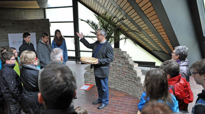 Pfarrer Dietmar Hermann vor der »Klagemauer«, eine der Stationen in der St. Andreas-Kirche. Das Interesse am Ostergarten ist eno