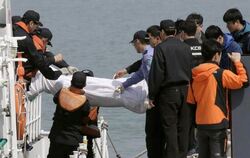 Die ersten Opfer des Fährunglücks werden aus dem untergegangenen Schiff geborgen. Foto: Kimimasa Mayama