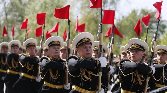 Mit roten Flaggen paradieren Soldaten am Grab des Unbekannten Soldaten vorbei. Foto: Yuri Kochetkov