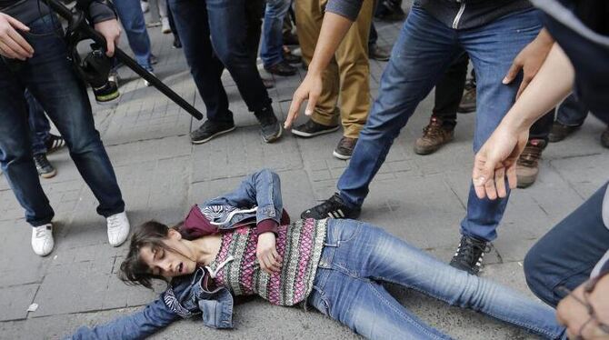 Polizisten in Zivil beugen sich über eine Demonstrantin. Foto: Sedat Suna