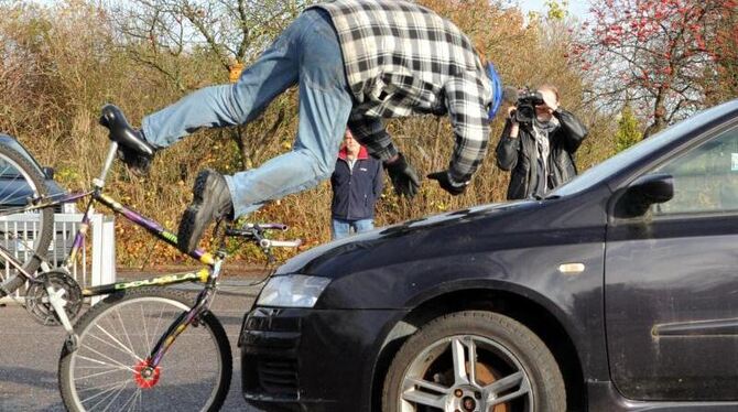 Ein Stuntfahrer demonstriert den Aufprall mit einem Fahrrad auf ein Auto. Foto: Carsten Rehder/Archiv