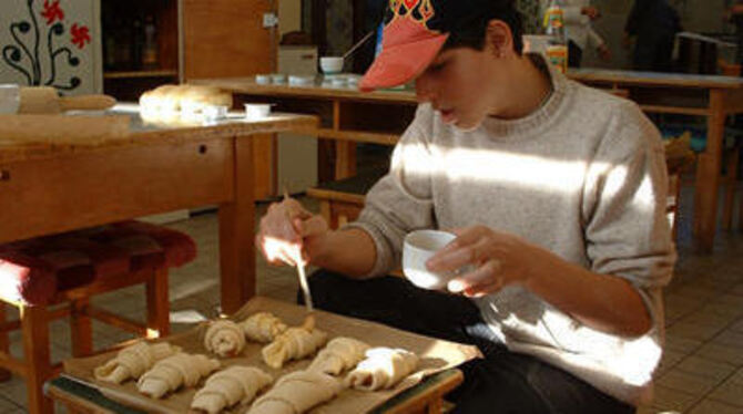Claudio bestreicht Schokohörnchen. 50 bis 60 Essensportionen bereitet das Kiosk-Team an der Oberlinschule an seinem Verkaufstag