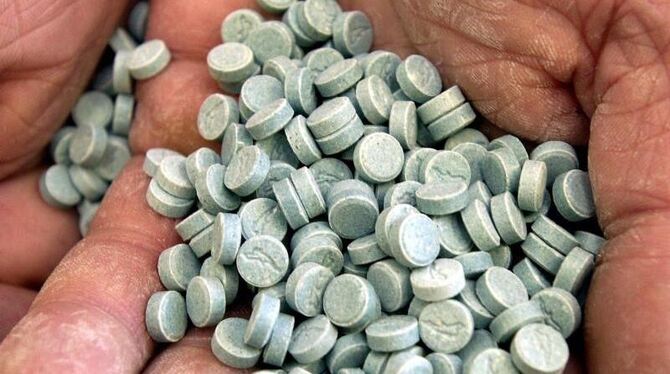 Ein Mitarbeiter des Drogendezernates der Polizei zeigt beschlagnahmte Ecstasy-Pillen. (Archivbild)
