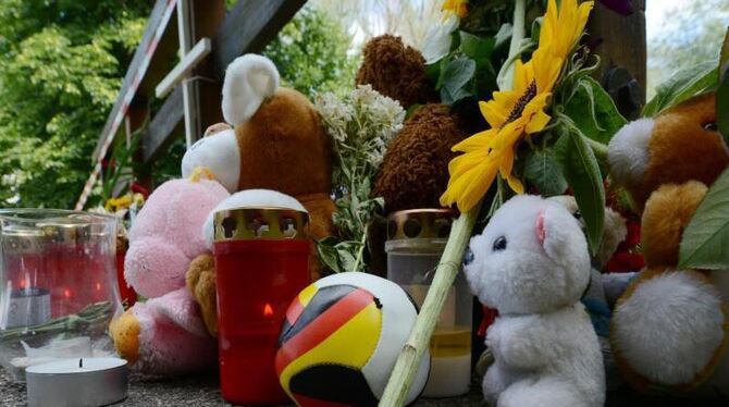 Kuscheltiere, Grablichter, ein Fußball und Blumen liegen in Freiburg am Fundort des getöten achtjährigen Jungen. Foto: Patric