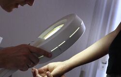 Ein Hautarzt untersucht die Haut einer Patientin bei einer Hautkrebs-Früherkennung. Foto: Karl-Josef Hildenbrand/Symbol
