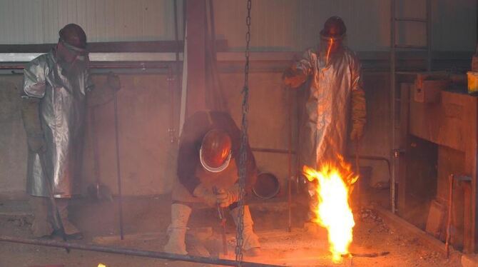 Bruder Michael und seine Helfer gießen 1 150 Grad heiße Bronze in die Glockenform. FOTO: DAIGLER
