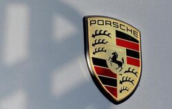 Der Schatten eines VW-Logos auf die Kühlerhaube eines Porsche. Foto: Franziska Kraufmann