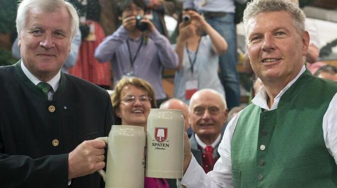 Der bayerische Ministerpräsident Horst Seehofer (l) und Münchens Oberbürgermeister Dieter Reiter stoßen an. Foto: Peter Kneff