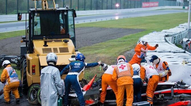 Helfer sind am Unfallort und kümmern sich um den verletzten Jules Bianchi. Foto: Hiroshi Ymamura