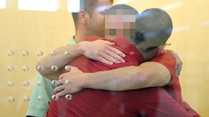 Die Angeklagten Abdeladim El-K. (r) und Amid C. umarmen sich während eines Termins im Gerichtssaal. Foto: Federico Gambarini