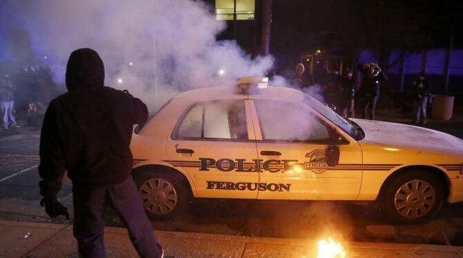 Demonstranten blockierten Straßenkreuzungen und griffen einen Wagen der Polizei in Ferguson an. Foto: Tannen Maury