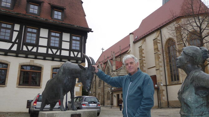 Albrecht Arnold, Leiter des Dettinger Heimatmuseums, mit den Skulpturen zwischen Rathaus und Stiftskirche.  FOTO: BERNKLAU
