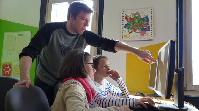 Annelie Bissinger und Evita Rauscher lernen von Marcel Kronfeld, eine Spiel-App für ihre Handys zu programmieren. FOTO: WEBER