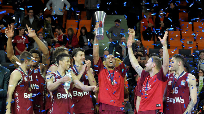 Münchens Spieler feiern nach einer dramatischen Schlussphase den Pokalsieg. Alex King reckt die Trophäe in die Höhe.  FOTO: DPA