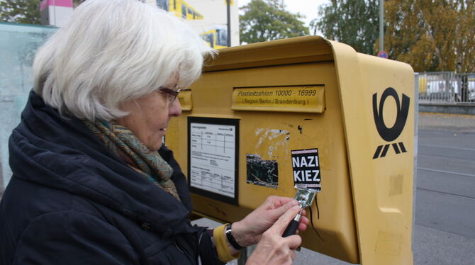 Irmela Mensah-Schramm führt eine scharfe Klinge, mit der sie rechte Aufkleber abkratzt. FOTO: MENSAH-SCHRAMM