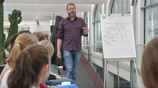 Illustrator Stefan Dinter zeigt Quenstedt-Schülern in der Mössinger Stadtbibliothek, wie ein Comic entsteht. FOTO: MEYER