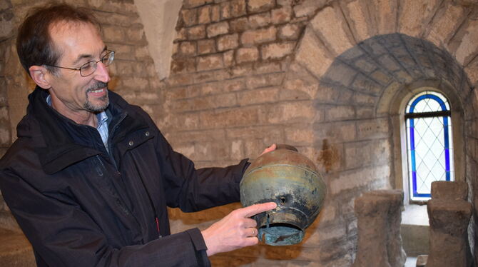 Pfarrer Eberhard Gläser zeigt auf das deutlich zu erkennende Einschussloch in der früheren Turmspitze der Johanneskirche. Es sol